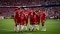 The image shows a group of FC Bayern Munich soccer players congratulating each other on the field during a game against 1. FC Köln in the 2026 season.