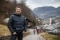 The image shows Georg Hackl standing on a footpath in his home town.