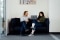 The image shows employees who are working with a laptop on a sofa.