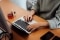 The image shows a content creator working in front of a laptop.