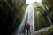 Das Bild zeigt einen Mann, der vor einem Wasserfall steht